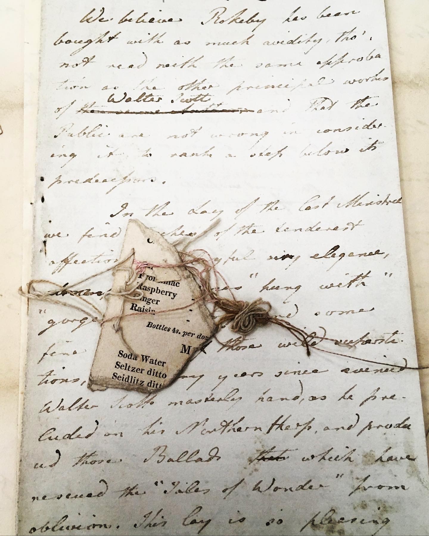 Old handwritten letter with attached label listing soda flavors.